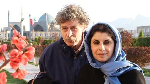 Faranak Djalali-Lorenz et Rüdiger Lorenz devant une mosquée à coupole bleue, au premier plan des branches en fleurs