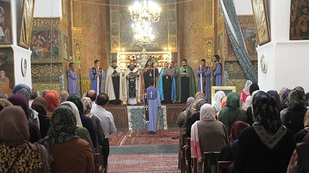 Service in a richly painted cathedral with clergy and congregation