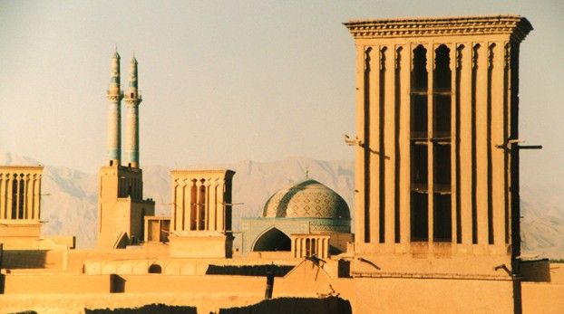 Tours à vent, minarets et coupole de mosquée au-dessus des toits en terre de Yazd