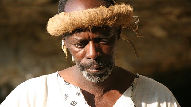 Portrait of a man with a fur headband and a white shirt