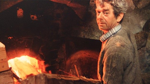 Man in front of the glowing fire of a lime kiln