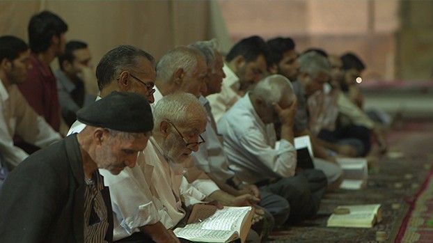 Men reading the Koran during prayer