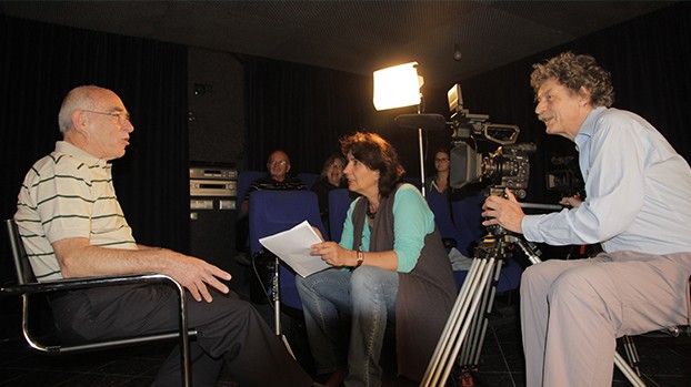 Interview with a contemporary witness in front of a camera and a spotlight